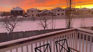 A residential area with houses and a snow-covered landscape during sunset. - Calgary Home | 3BR Home | Sleeps 6 | Parking | 15min to Downtown (Calgary)