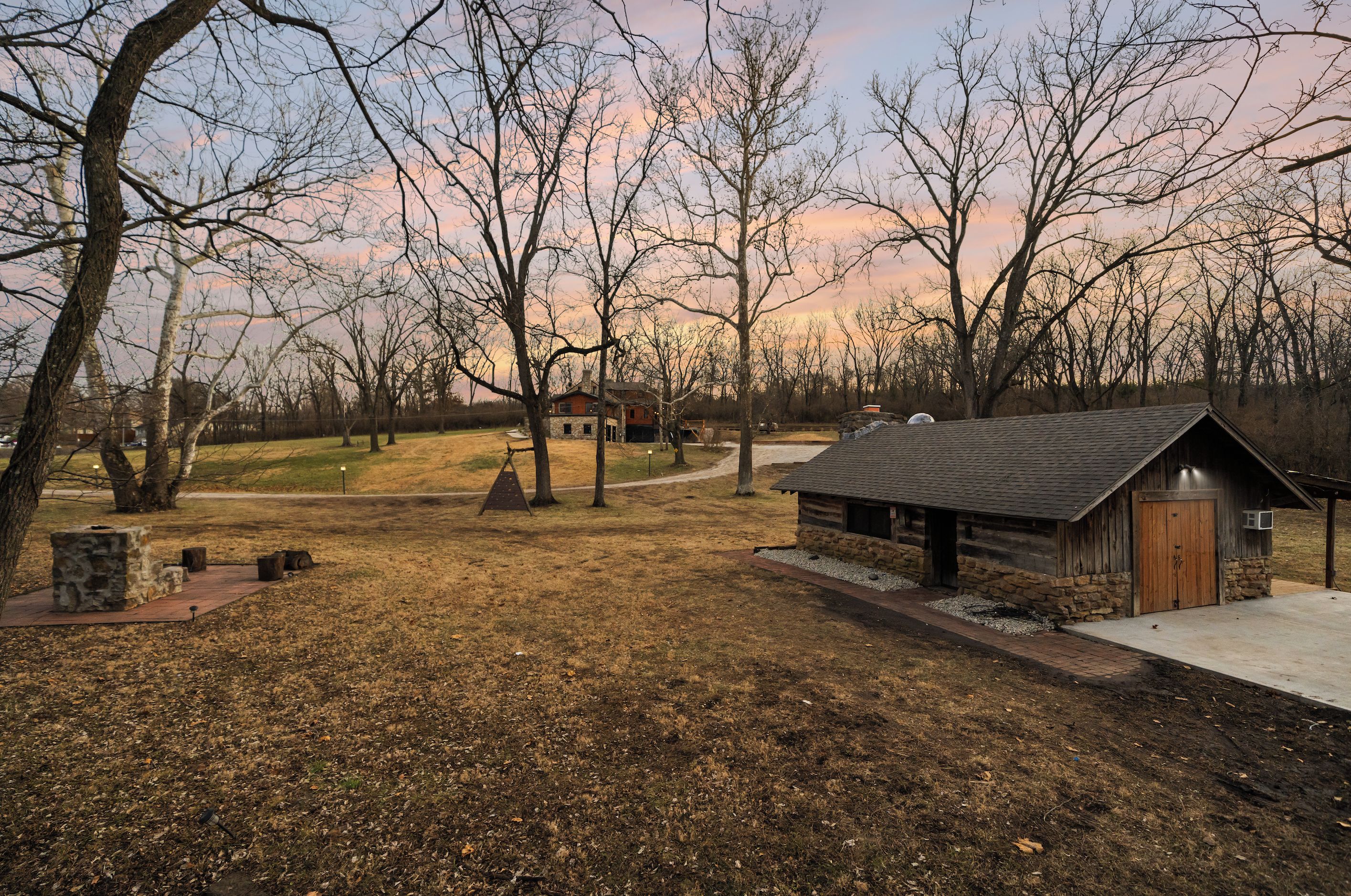 A rustic cabin with a stone foundation, a wooden door, and a small porch area.