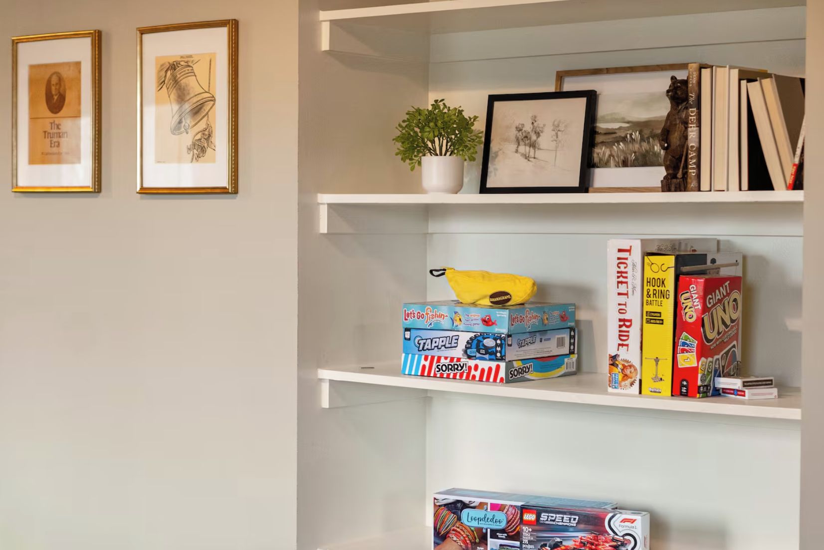 A bookshelf with framed pictures, books, and children's toys.