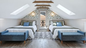 Quarto com duas camas, claraboia e vista para o exterior.
