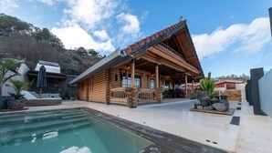 A wooden cabin with a pool, stone steps, and outdoor seating. - Cabin Tranquil Organic Heated Pool (La Solana)