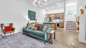A modern living room with a sofa, a chair, a dining table, and a kitchen in the background. - Three bedroom  in United States of America, Spartanburg (Spartanburg)