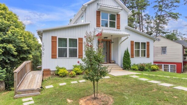 A two-story house with a front porch, a small tree in the front yard, and a wooden deck. - Three bedroom  in United States of America, Spartanburg (Spartanburg)