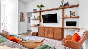 A living room with a sofa, a chair, a television, and a cabinet. - Three bedroom  in United States of America, Spartanburg (Spartanburg)