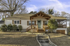 A single-story house with a front porch, a garage, and a small front yard.