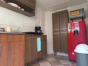 Eine Küche mit Holzausstattung, einem roten Kühlschrank und einer Kaffeemaschine.