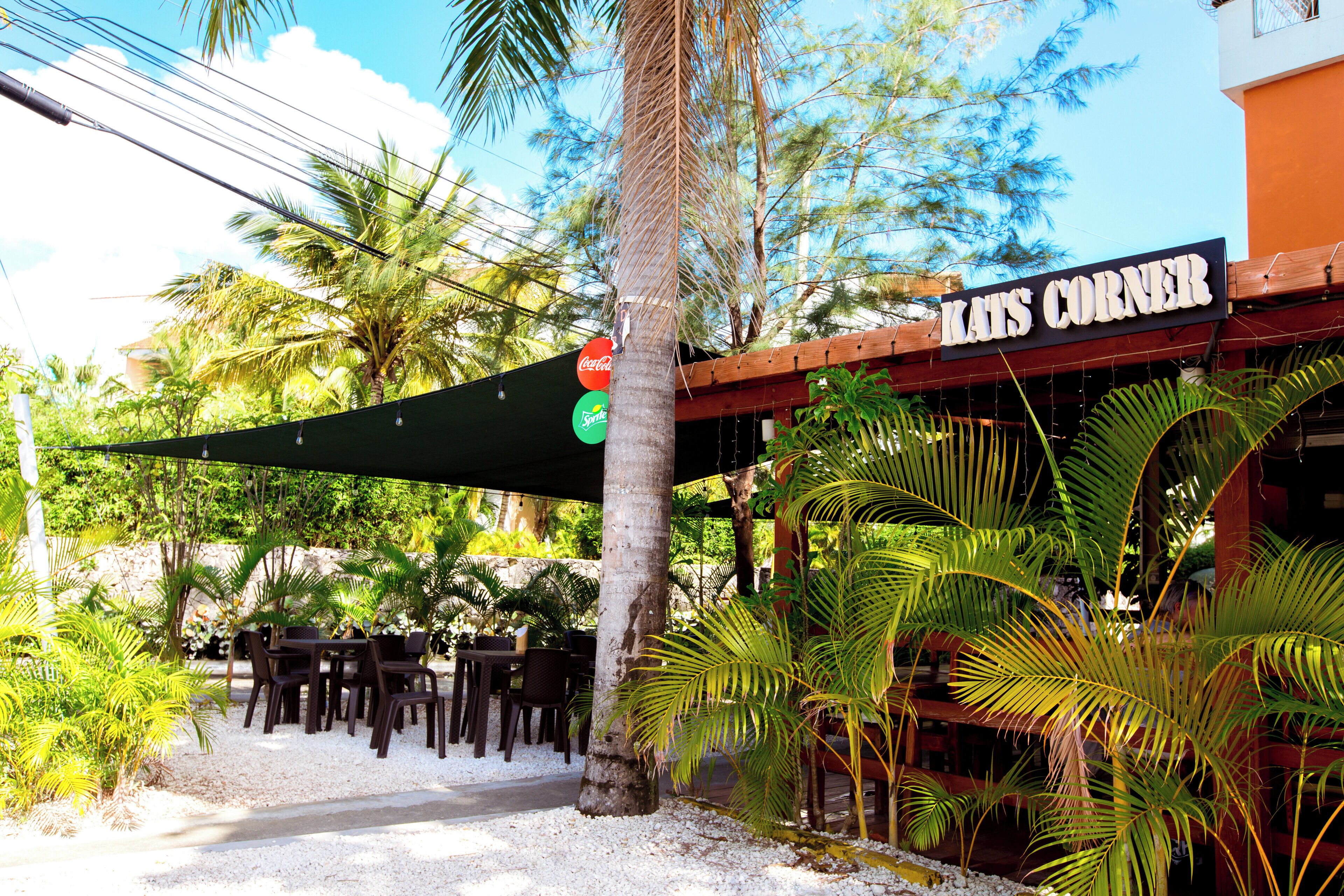 Un restaurante llamado 'Los Corner' con terraza y palmeras.