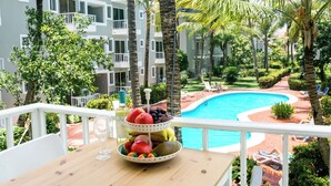 A balcony with a fruit bowl, a glass, and a bottle of wine. - BRISAS TROPICAL playa LOS CORALES (Punta Cana)
