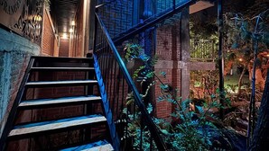 A staircase with metal railings, surrounded by greenery and brick walls. - Hotel Casa Grangelo (Atlixco)