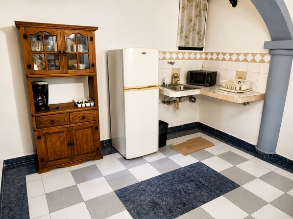 A kitchen with a wooden cabinet, a white refrigerator, a microwave, and a sink. - Villa Madre by La Cultura Suites (Playa del Carmen)