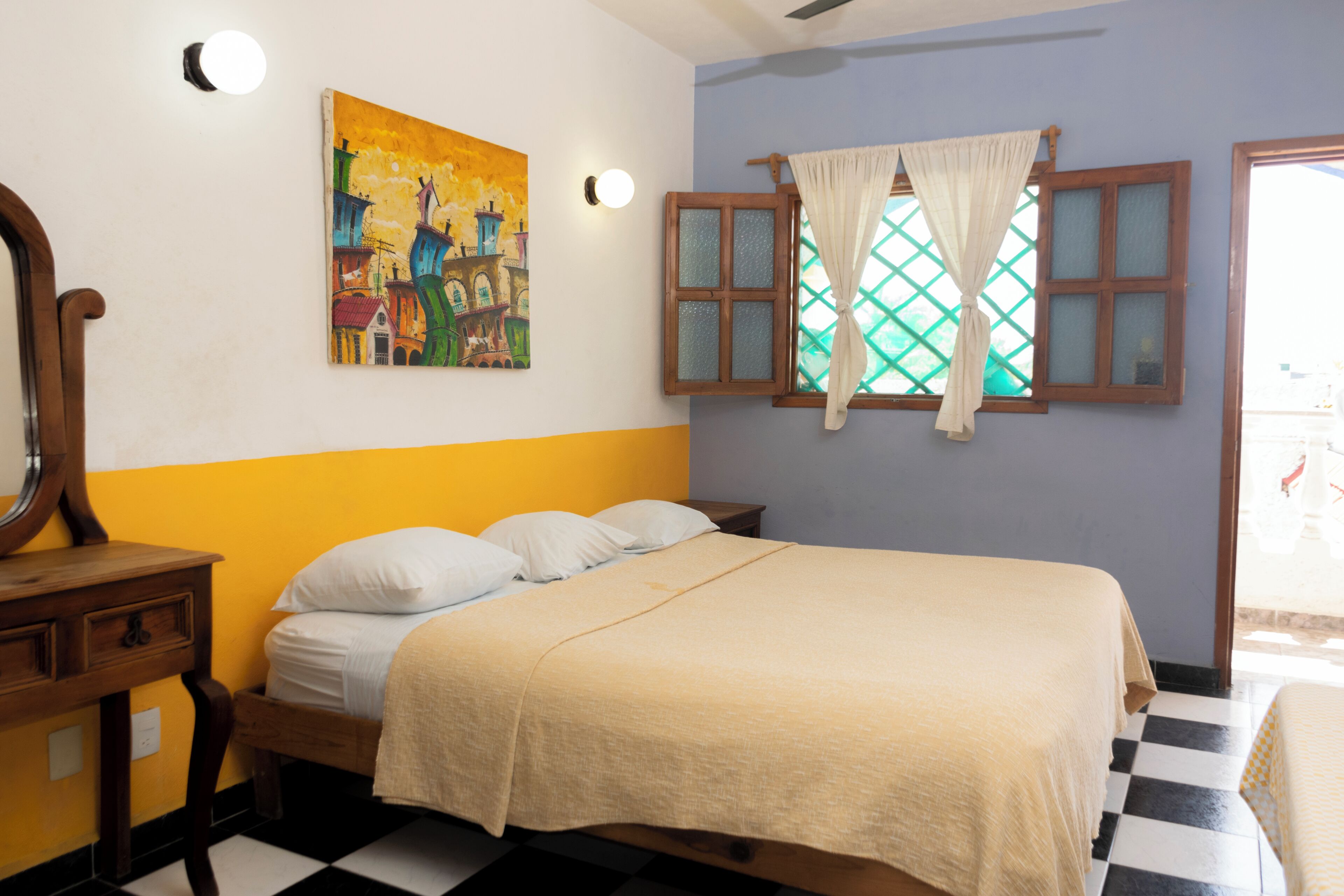 A room with a bed, a wooden nightstand, a painting, and a window with curtains.