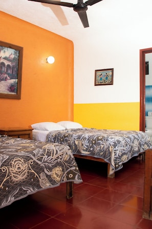 A room with two beds, a ceiling fan, a painting on the wall, and a light fixture. - Villa Madre by La Cultura Suites (Playa del Carmen)