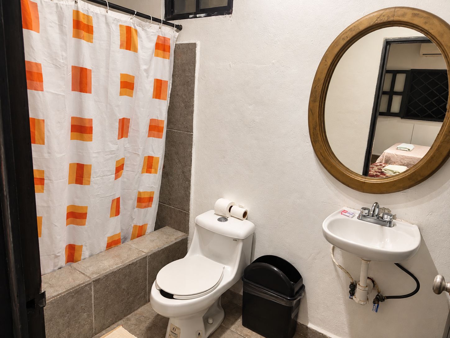 A bathroom with a toilet, sink, and shower curtain.