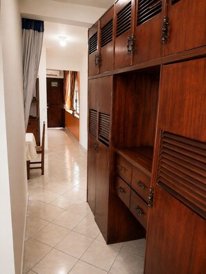A hallway with a wooden wardrobe, a chair, and a door marked 'SALIDA EXIT'.