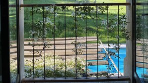 A balcony with a view of a green landscape and a swimming pool. - Luxueuse maison de campagne isolée, nichée dans la forêt au milieu des oiseaux. (Lesparrou)