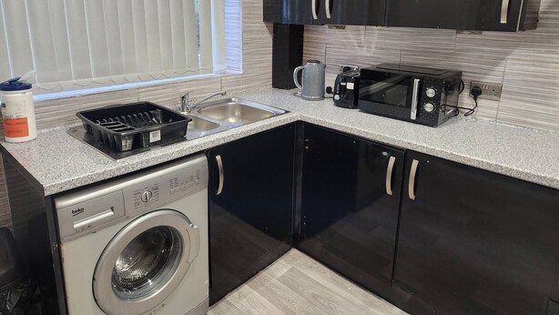 A compact kitchen with a washing machine, a sink, and a toaster. - Come and Enjoy My Peaceful Home, Your Comfort Zone (Manchester)