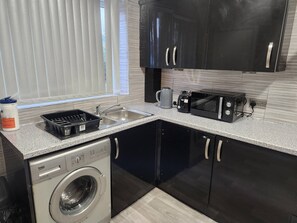 A compact kitchen with a washing machine, a sink, and a toaster. - Come and Enjoy My Peaceful Home, Your Comfort Zone (Manchester)