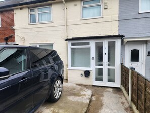 A residential property with a garage, a white door, and a window. - Come and Enjoy My Peaceful Home, Your Comfort Zone (Manchester)