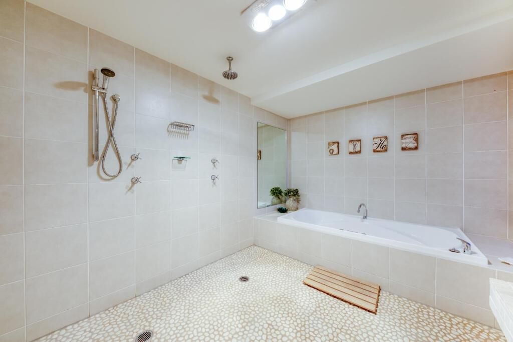 Un baño moderno con ducha, bañera y suelo de baldosas.