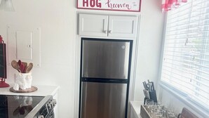 A compact kitchen with a stainless steel refrigerator, wooden flooring, and a sign that reads "HOG heaven." - On Razorback Trail!  Walk to Dickson, Stadium & UARK (Fayetteville)