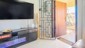 Un saló modern amb televisió de pantalla plana, una taula de consola i una porta decorativa.