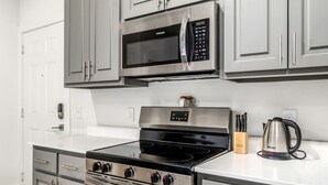 A modern kitchen with stainless steel appliances, including a microwave, oven, and stovetop. - Stylish Suite • Downtown • Convention Center (Hot Springs)