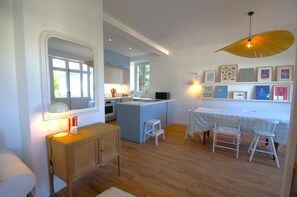 Une cuisine moderne dotée d’un îlot central, de meubles en bois et d’un coin repas avec une table et des chaises.