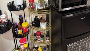 A kitchenette with a coffee maker, microwave, and a spice rack with various condiments. - Private Suite: Hotel Perks, Snacks & Fast WiFi near Baltimore & Top Hospitals (Nottingham City)
