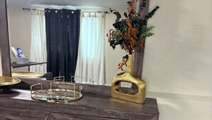 A wooden dresser with a mirror, a gold vase with greenery, and a gold tray. - Private Suite: Hotel Perks, Snacks & Fast WiFi near Baltimore & Top Hospitals (Nottingham City)