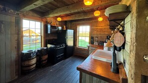 Une cuisine rustique avec des murs en bois, une grande fenêtre et un plafond en bois.