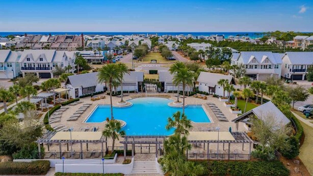 Et resort med en central swimmingpool, flere villaer og udsigt over havet.