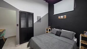 A modern bedroom with a bed, a wardrobe, a desk, and a chair. - Prado House in Medellin 8BR & Terrace (Medellín)