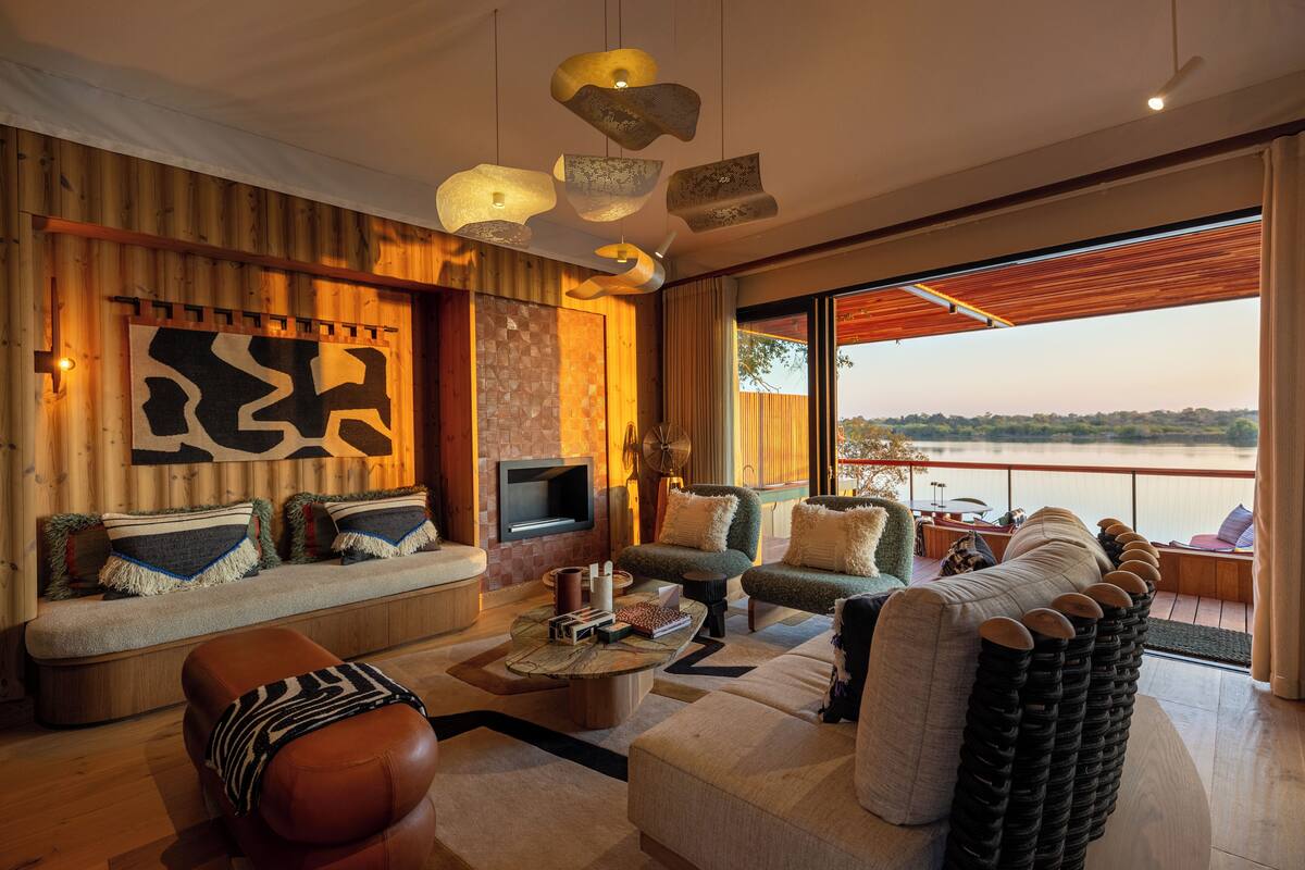 A modern living room with a large window, a flat-screen TV, and a variety of seating options.