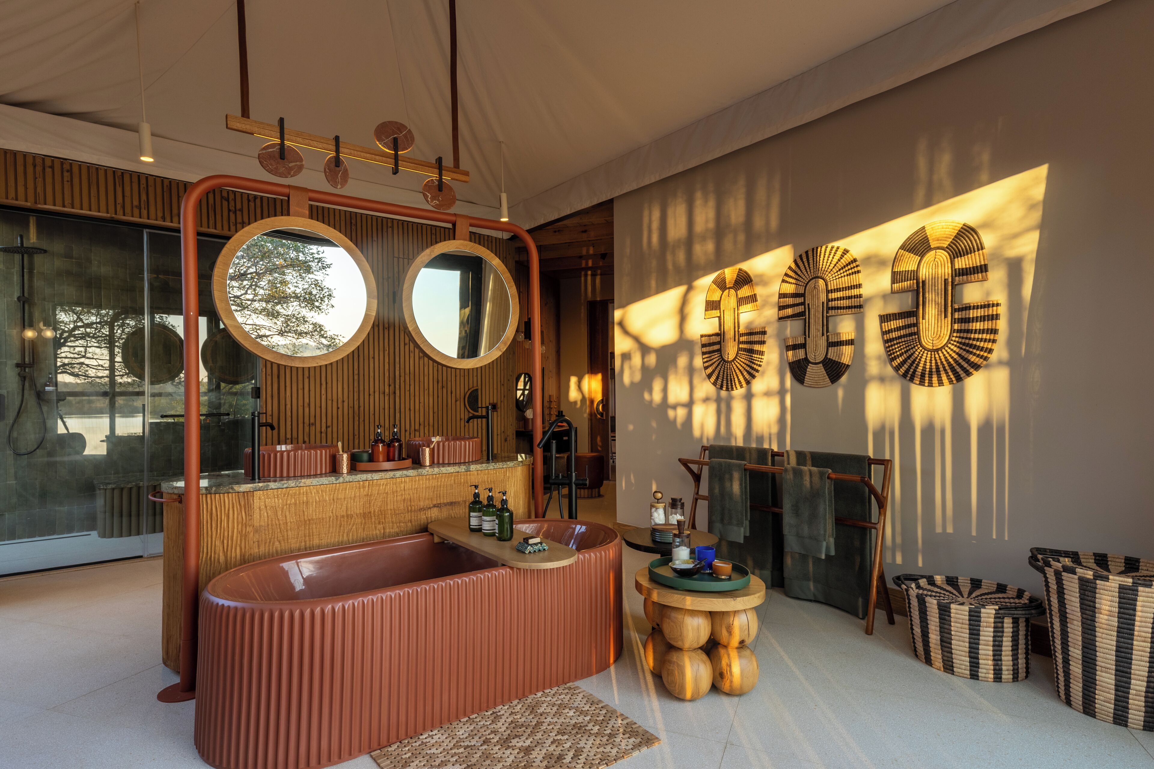 A modern bathroom with a large bathtub, two mirrors, and a wooden vanity.
