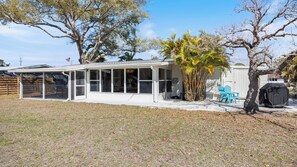 A house with a covered patio, a fenced yard, and a tree. - Casa del Sol - Venice Island Beach Escape (Venice)