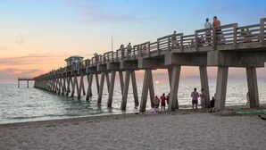 A pier extending into the water with people walking along it. - Casa del Sol - Venice Island Beach Escape (Venice)