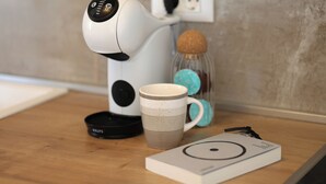 A coffee maker, a mug, a glass jar with a cork stopper, and a small booklet on a wooden surface. - Valmere Apartment Tivat Sea View Free Parking (Tivat)