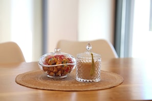 Uma mesa com uma tigela de vidro transparente e um pote de vidro com tampa.