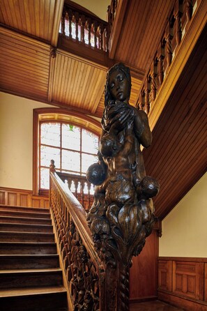 Eine prächtige Treppe mit aufwendigen Holzschnitzereien und einer großen Statue oben.