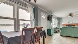 A dining area with a table and chairs, a sofa, a television, and a fireplace.