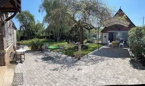 Een binnentuin met buitenplaatsen, een bakstenen gebouw en een tuin.