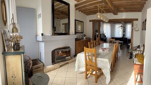 A cozy living room with a fireplace, wooden dining table, and chairs. - Large family home in Saint-Mards-en-Othe (Saint-Mards-en-Othe)