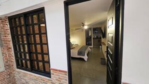 A room with a bed, a small kitchenette, and a bathroom. - Naranjo Cozy Loft w/AC in Laureles (Medellín)