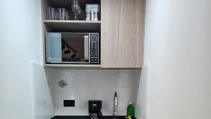 A compact kitchen with a microwave, coffee maker, and a sink. - Naranjo Cozy Loft w/AC in Laureles (Medellín)