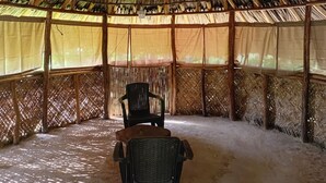 A thatched-roof structure with a woven fence, a table, and two chairs. - Entire finca with 3 bedrooms, 3 bathrooms and private waterfall (Minca)