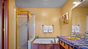 A bathroom with a bathtub, a shower, and a sink with a decorative tile backsplash.