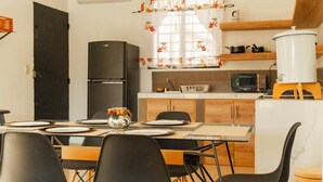 A compact kitchen with a refrigerator, microwave, and a coffee maker on a stand. - Casa con la mejor ubicación a minutos de Xetulul (Santa Cruz Muluá)