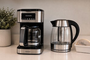 Une machine à café BLACK+DECKER et une cafetière en acier inoxydable sur un plan de travail de cuisine.