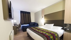 A hotel room with a bed, a desk, a chair, a TV, and a window with curtains. - Ibis Styles Saint Quentin (Saint-Quentin)