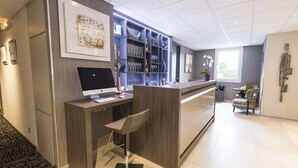 A modern hotel lobby with a reception desk, computer, and bar area. - Ibis Styles Saint Quentin (Saint-Quentin)